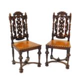 A pair of Victorian 17thC style oak single dining chairs, with floral and foliate carved backs,