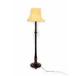 An Edwardian black Japanned lacquer standard lamp, raised on three brass lion paw feet, with
