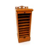 A Victorian oak tambour fronted chest, opening to reveal nine slides, raised on a plinth base, on