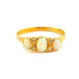 An 18ct gold and opal three stone ring, set with pairs of diamonds at intervals, size U, 3.3g.