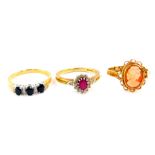 A 9ct gold ruby and diamond ring, size Q, a 9ct gold and sapphire three stone ring set with pairs of