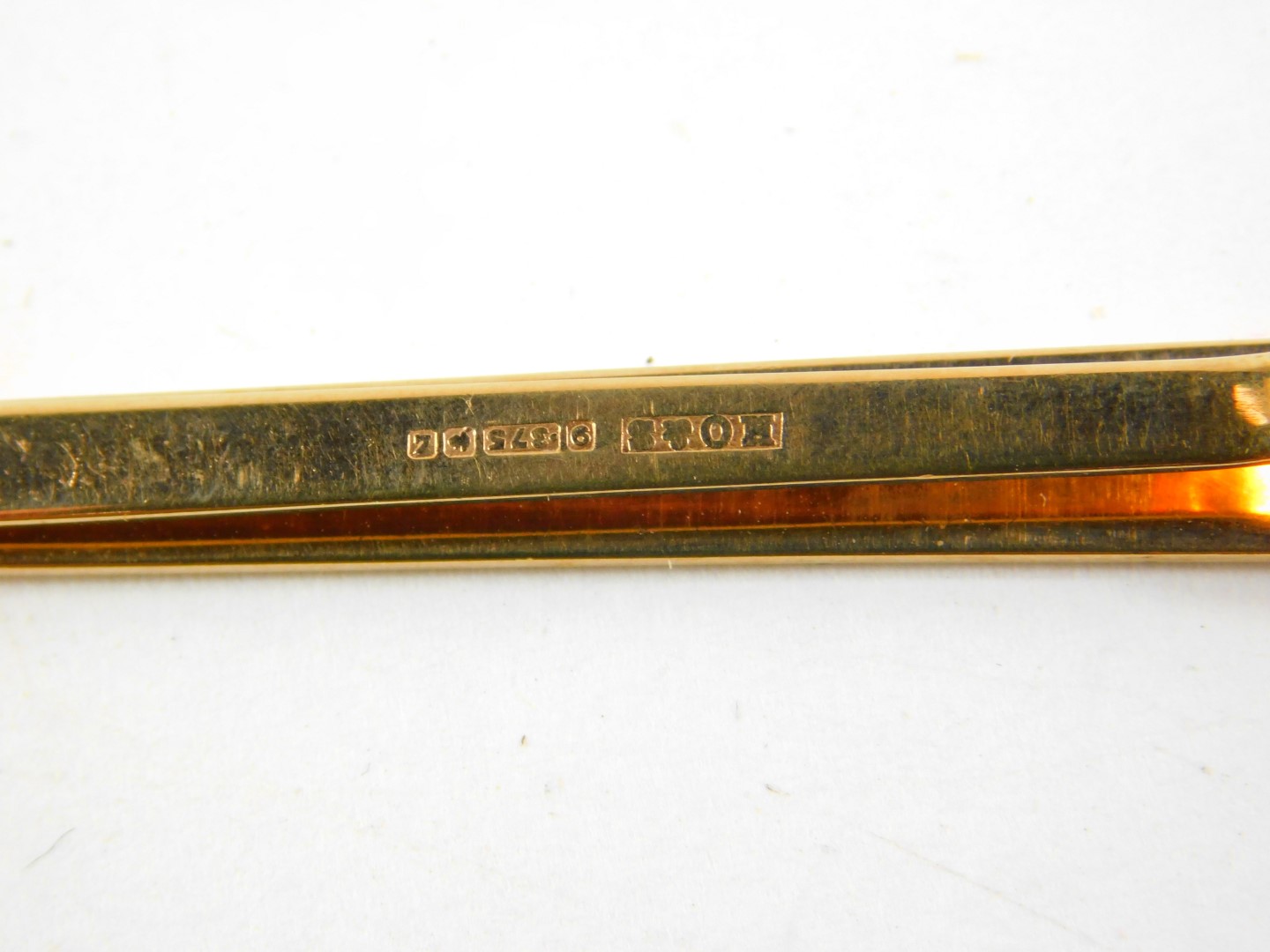A 9ct gold tie slide, with engine turned decoration and safety pin as fitted, 6.2g. - Image 2 of 2