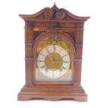 A Lenzkirk oak cased mantel clock, domed brass dial with rococo floral and foliate scroll spandrels,