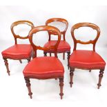 A set of four Victorian mahogany balloon back dining chairs, with overstuffed red leatherette seats,
