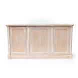 A limed beech and ash sideboard, with three doors opening to reveal drawers and shelves, raised on a