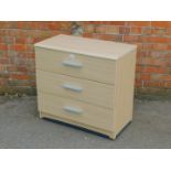 An oak laminate chest of three drawers, 73cm high, 77cm wide, 41cm deep.