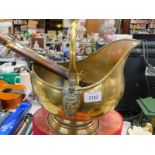 A brass coal bucket with ceramic handles and an Indian wooden handled steel carving knife and