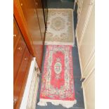 Two Chinese wool runners, one pink ground with a floral design, 140cm x 63cm, the other cream ground