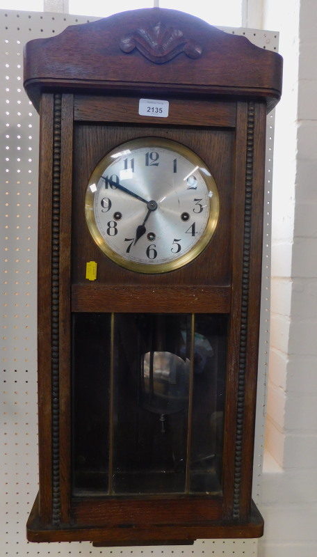 An oak cased wall clock, circular silvered dial bearing Arabic numerals, eight day movement with