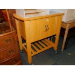A beech kitchen unit, with cupboard and lower shelf raised on castors, 89cm high, 85cm wide, 54cm