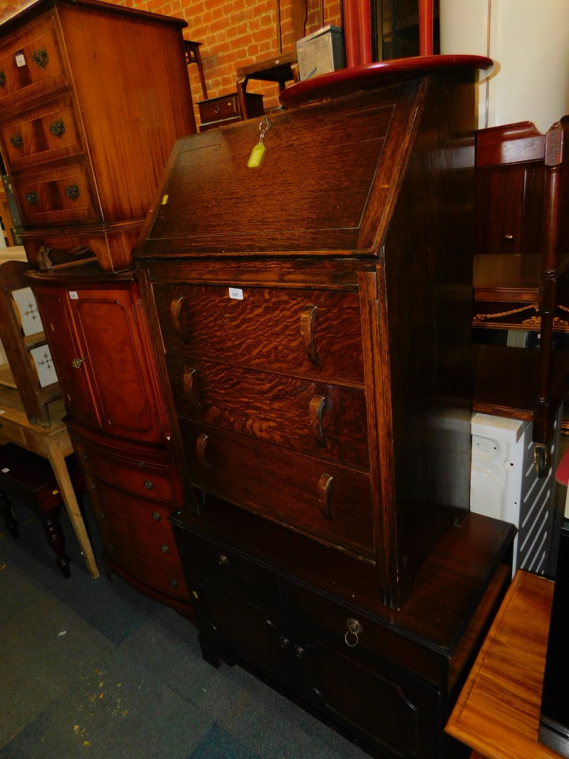 An oak bureau with three drawers, 100cm high, 69cm wide, 40cm deep., together with a mahogany TV