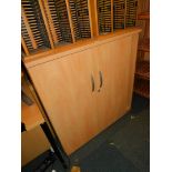 A beech laminate narrow office cupboard, 101cm high, 98cm wide, 30cm deep.