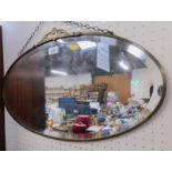 An Art Deco style oval mirror, brass mounted, 61cm wide.