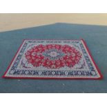 A Belgium polyester rug, of red ground with blue and cream borders and floral design, 227cm x