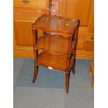A Reprodux three tier mahogany table, each tier having galleried sides and raised on outswept