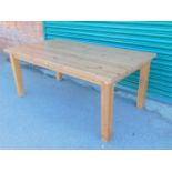 An IKEA pine refectory table, raised on square legs, 75cm high, 180cm wide, 101cm deep.