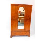 An early 20thC walnut double wardrobe, with a central mirrored door, over a frieze drawer raised