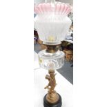 An oil lamp, with plain glass reservoir and acid etched and fluted shade with cranberry crimped