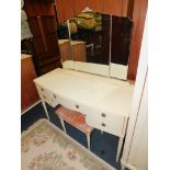 A Butilux French style cream painted bow front dressing table, with tryptic mirror, over five