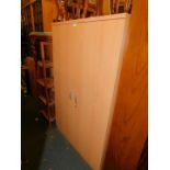 A beech laminate office cupboard, enclosing three adjustable shelves, 161cm high, 96cm wide, 51cm