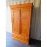 A pine two door wardrobe, with lower drawer, 198cm high, 115cm wide, 58cm deep.