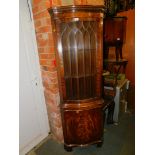 A reproduction mahogany serpentine corner cabinet, together with lower cupboard, 180cm high.