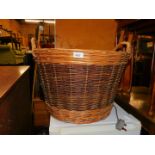 A wicker basket, with two handles and darker central band decoration, 40cm high, 53cm diameter.