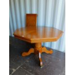 An oak veneered octagonal dining table, raised on a pedestal base, with additional leaf, 76cm