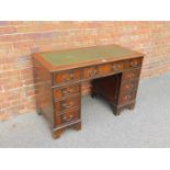 A reproduction mahogany twin pedestal desk, with tooled green leather insert over an arrangement