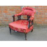 A late Victorian stained mahogany salon chair, upholstered in red and gold floral brocade.