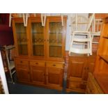 A stained oak laminate display unit, with lead glazed upper section, over three drawers and three