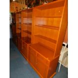 Three teak laminate Stag bookcases, the bases having two drawers over two cupboard doors, raised