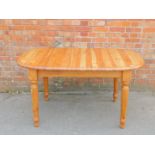 A pine extending dining table, raised on turned legs, 76cm high, 142cm wide, 182cm extended, 92cm