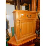 A pine bedside cabinet, with deep panelled door and drawer, reeded moulding and raised on bracket
