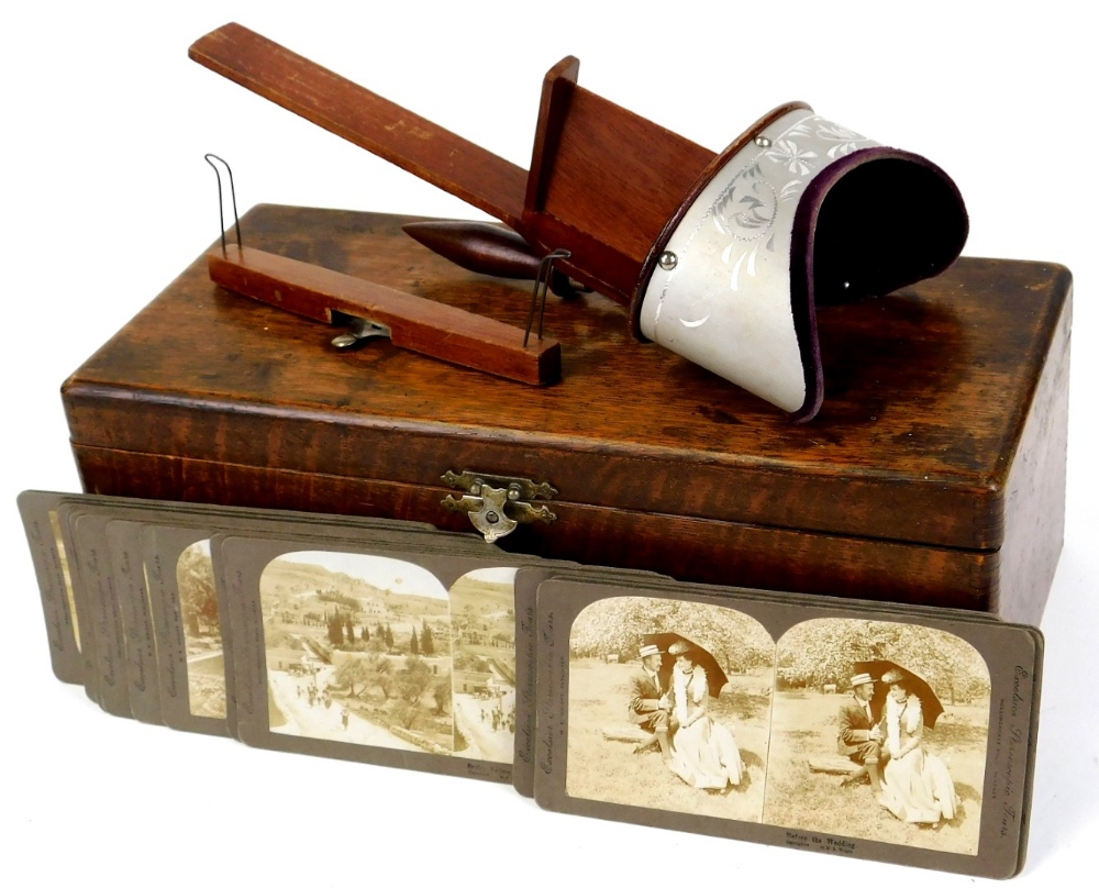 An early 20thC stereoscopic viewer, with a number of cards in oak case, cards to include Before