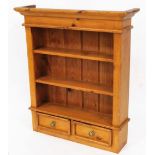 A pine open front bookcase, with three shelves above two drawers on a plain block base, 96cm high,