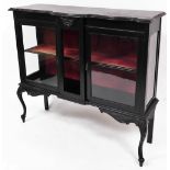 An early 20thC ebonised display cabinet, of serpentine form with a glazed front, removable shelves