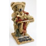 A Liberty and Co style advertising Teddy bear set, with buttons on a shaped stand, 33cm high.