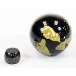 A 20thC studio Our Glass paperweight of globular form, in black and gilt colour way
