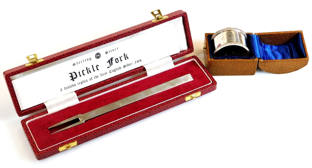 An Elizabeth II cased pickle fork, after the antique, Sheffield 1977, 18cm wide and a cased napkin