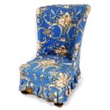 A late 19thC open wing chair, upholstered in later floral material on compressed oak square front