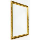 A rectangular gilt mirror, with inner bead and outer floral border, with bevel glass, 121cm high,