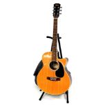 A Swift Music London six string acoustic guitar, 99cm high, with canvas case and stand.