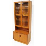 A vintage G Plan bookcase, with a double door glazed front raised above double cupboard beneath on a