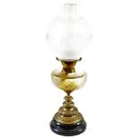 An early 20thC oil lamp, with frosted and clear glass shade, shaped glass reservoir, turned stem and