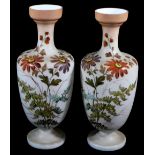 A pair of early 20thC hand painted milk glass vases, each of shouldered tapering form decorated with