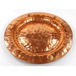 An early 20thC copper Arts & Crafts wall plaque, of circular form, with hammered raised centre and