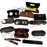 Various vintage spectacles, a pair of tortoise shell examples with gold coloured curved side bars,