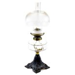 An early 20thC oil lamp, with frosted and clear glass shade, moulded glass reservoir and cast iron