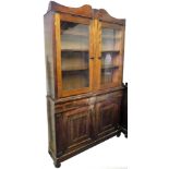 A Victorian mahogany bookcase, with fixed cornice, raised above two doors, revealing shelves,